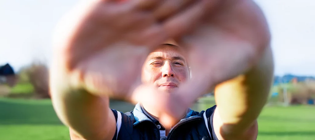 Golfprofi Felix Proske mit Blick durch Hände – Konzentration auf Zieltechnik beim T9 Open