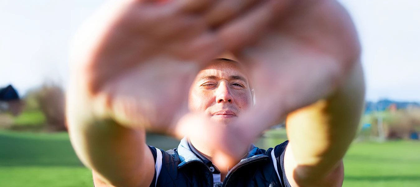 Golfprofi Felix Proske mit Blick durch Hände – Konzentration auf Zieltechnik beim T9 Open