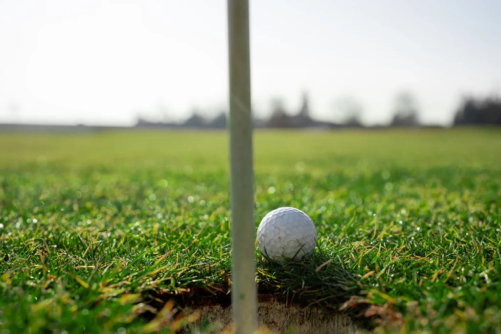 Golfball an der Fahne – Nahaufnahme kurz vorm Einlochen beim Triple Nine Open