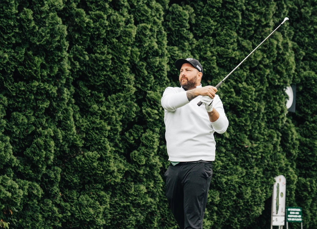 Golfer beobachtet den Ballflug nach einem Abschlag in Richtung Fahne mit der Chance auf ein Ass im Golf.